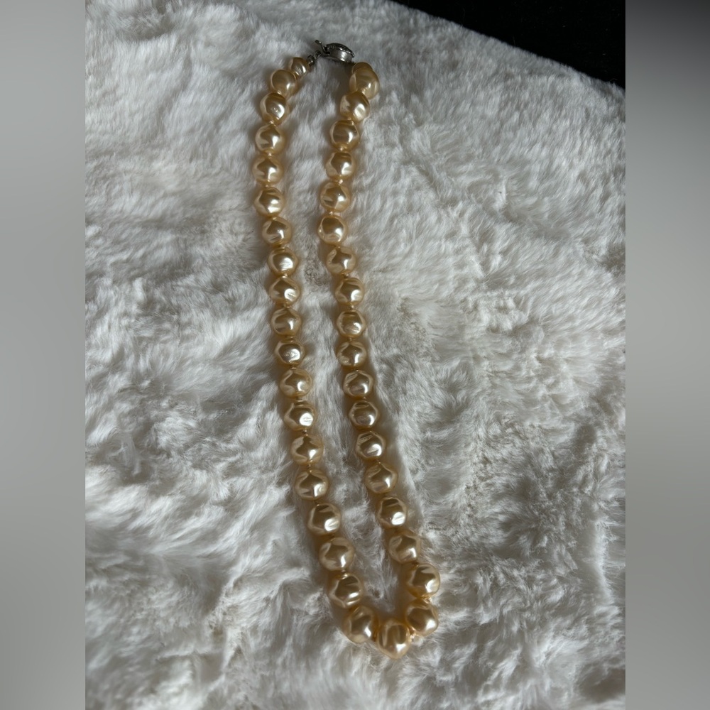 String of large faux pearls.